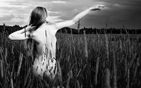 [Image decription: a slim white woman with long brown or blonde hair is walking through a field of tall grass with her right arm outstretched. We see her from behind and she is naked, although the grass is covering her to the waist. The photo is in black and white] bdsm classes in toronto peterborough new york city